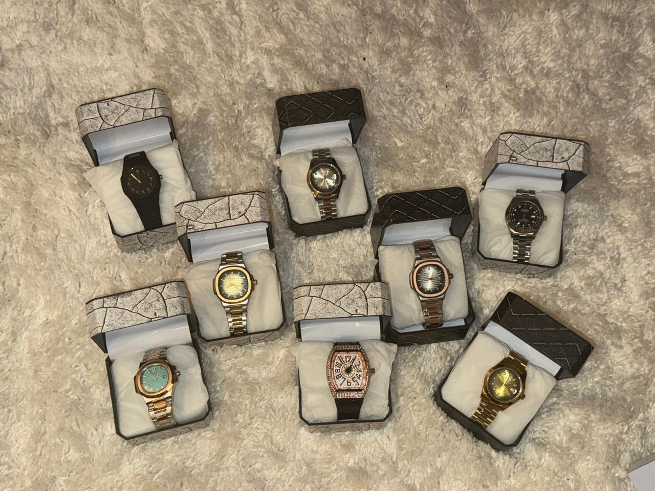 Multiple watches in display boxes on a textured surface